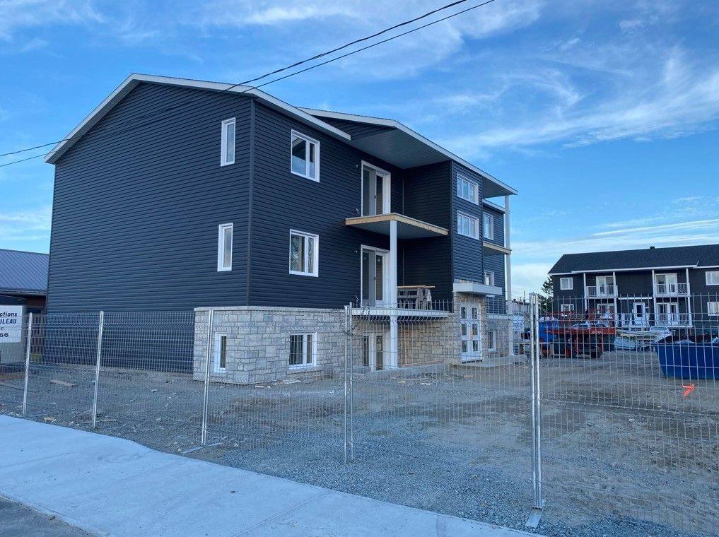 Un immeuble à logements de trois étages au revêtement bleu foncé, monté à partir de murs en panneaux
